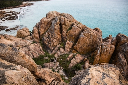 Reddish-brown rock formations along the coastline in Castle Rock - Australian Stock Image