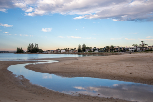 Reflections of clouds in water at Lady Robinsons Beach - Australian Stock Image