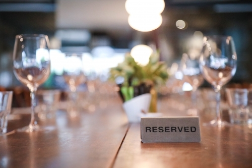 Reserved sign on table setting in fine dining restaurant - Australian Stock Image