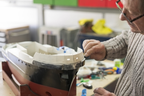 Retired Caucasian Man Working On Hobby Model Boat - Australian Stock Image