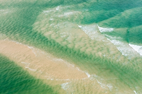 rips and currents stirring sand as the tide changes - Australian Stock Image