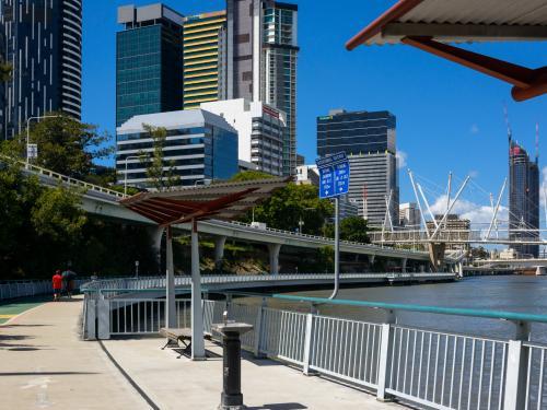 Riverside shared pathway with drinking fountain, shelter and pedestrian in the background. - Australian Stock Image