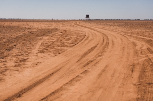 Road leading to a tank in a barren paddock - Australian Stock Image