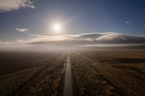 Road to the sky with the fog clouds coming through and the sun shining over the clouds - Australian Stock Image