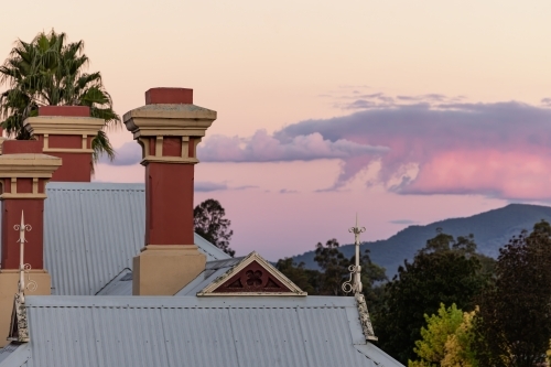 Rooftop of the historic Mudgee Railway Station with pink and purple twilight sky - Australian Stock Image