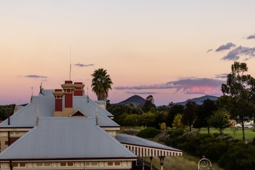 Rooftop of the historic Mudgee Railway Station with pink and purple twilight sky - Australian Stock Image