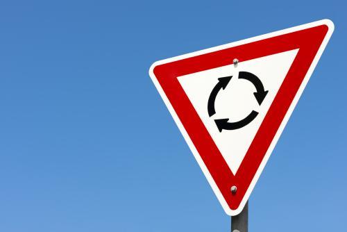 Roundabout sign against clear blue sky - Australian Stock Image