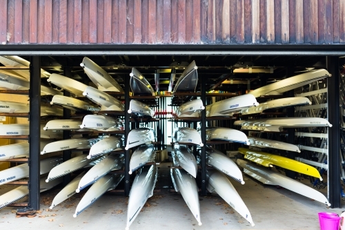 Rowing boats stacked in a boat house - Australian Stock Image