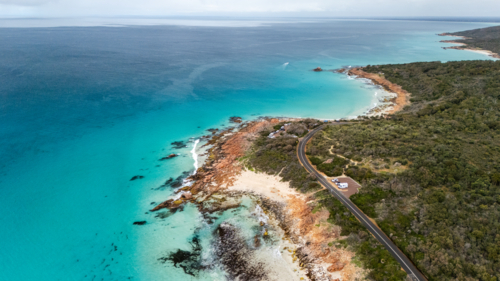 Rugged coastal promontory with rugged cliffs plunging through turquoise waters - Australian Stock Image
