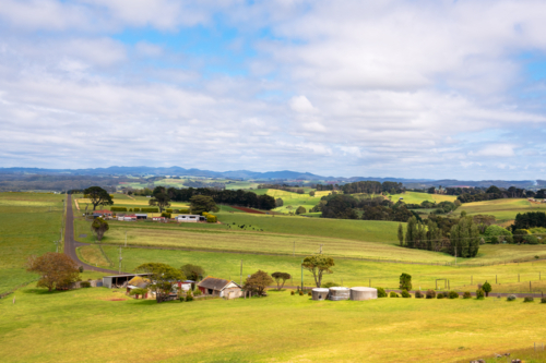 Rural valley landscape with farm buildings and hills in the distance, Tasmania - Australian Stock Image