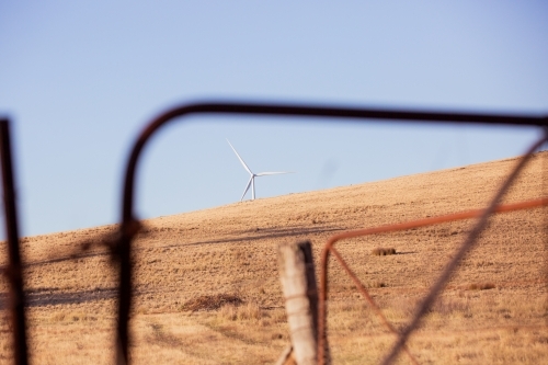 Rural Wind Turbines in a farm setting with a paddock gate in foreground - Australian Stock Image