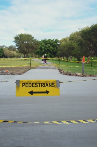 Safety black and yellow tape with pedestrians sign at the park
