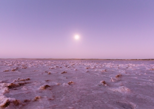 Salt flat foreground under a soft purple, pink sky. - Australian Stock Image