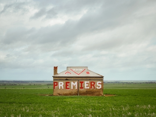 Sandstone cottage in field with graffiti - Australian Stock Image