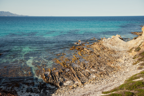 Seascape of rocky shoreline and blue water - Australian Stock Image