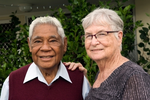Senior couple standing outdoors smiling together - Australian Stock Image