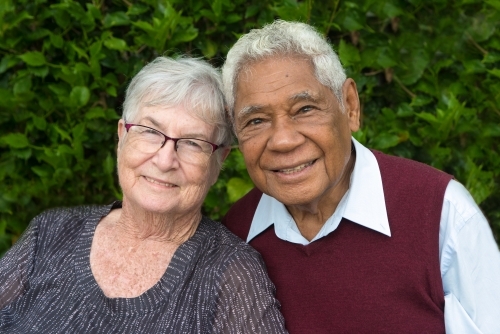 Senior couple together outdoors smiling at the camera. - Australian Stock Image