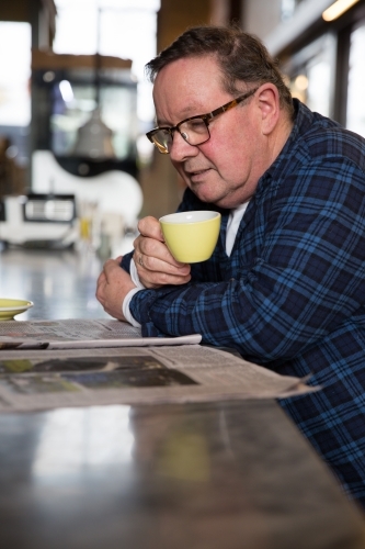 Senior Man Enjoying Coffee and Paper - Australian Stock Image