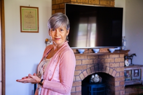 senior woman standing in her living room - Australian Stock Image