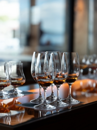 Series of glass wares filled with whisky for tasting - Australian Stock Image