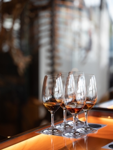 Series of glass wares filled with whisky for tasting - Australian Stock Image