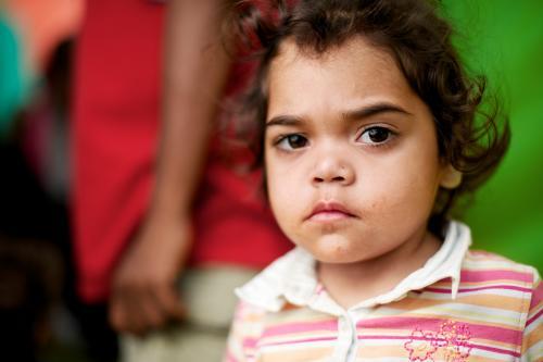 Serious young Aboriginal Girl wearing pink striped shirt - Australian Stock Image