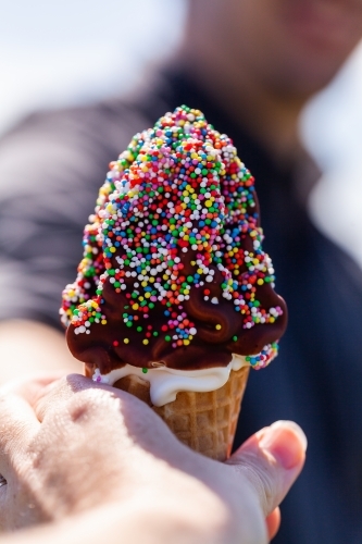 sharing ice cream dessert outdoors on summers day - Australian Stock Image