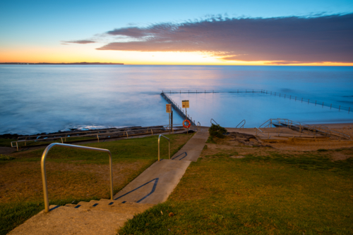 Shelly Park ocean pool and walkway at sunrise - Australian Stock Image