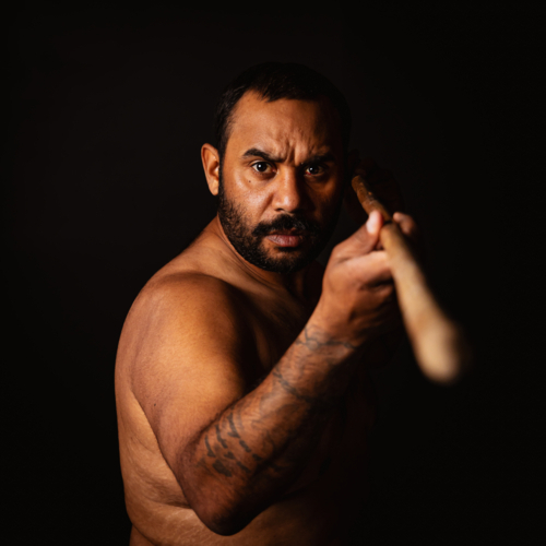 Shirtless aboriginal man holding a wooden spear - Australian Stock Image
