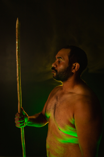 Shirtless aboriginal man holding a wooden spear - Australian Stock Image