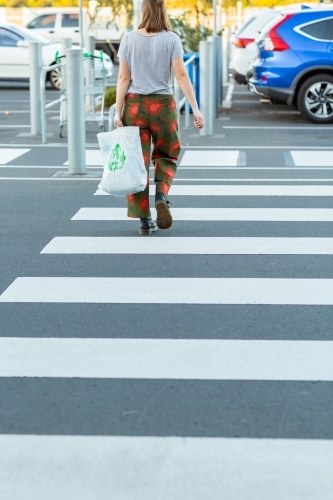 shopper walking across crosswalk at shopping centre carpark - Australian Stock Image