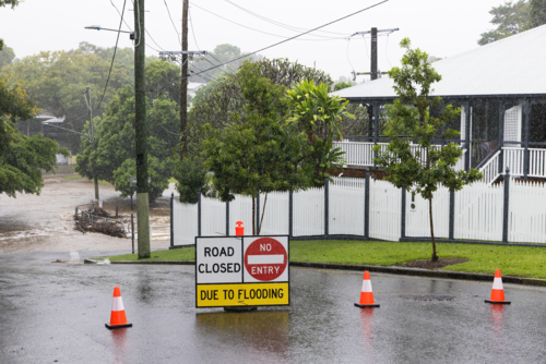 Signage across a flooded suburban road to stop traffic proceeding during a major rain event - Australian Stock Image