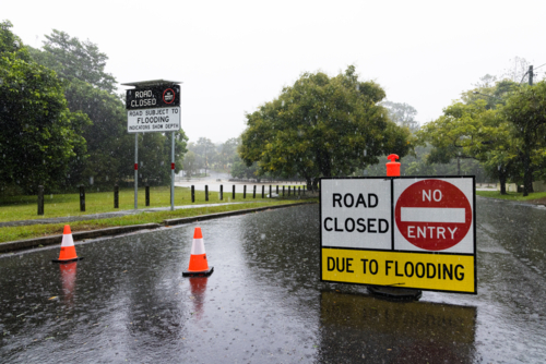Signage on a road showing it is closed due to flooding in suburban Brisbane - Australian Stock Image