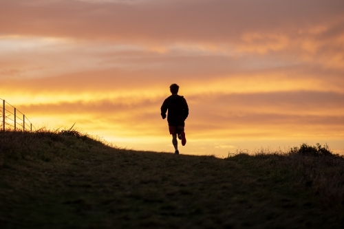 Silhouette of Man Running at Sunrise - Australian Stock Image