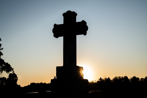 silhouette shot of a large cross in the cemetery - Australian Stock Image