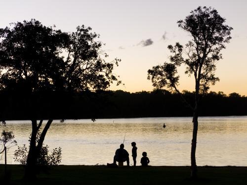 Silhouetted father and two son fishing - Australian Stock Image