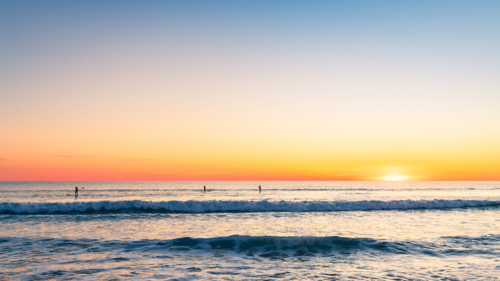 Silhouettes of people paddleboarding at Southport beach in Port Noarlunga, South Australia - Australian Stock Image