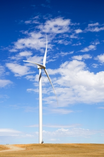 Single wind turbine against blue sky with white clouds - Australian Stock Image