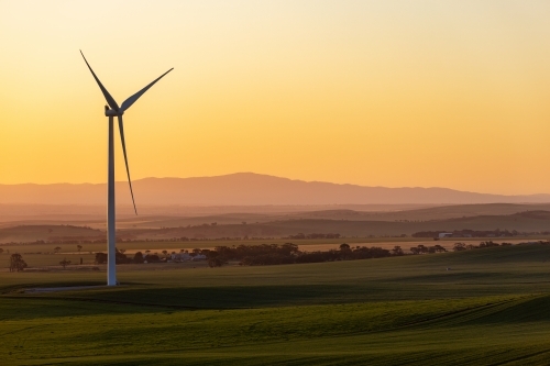 single wind turbine against golden afternoon sky - Australian Stock Image