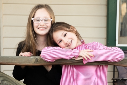 Sisters posing together on the veranda - Australian Stock Image