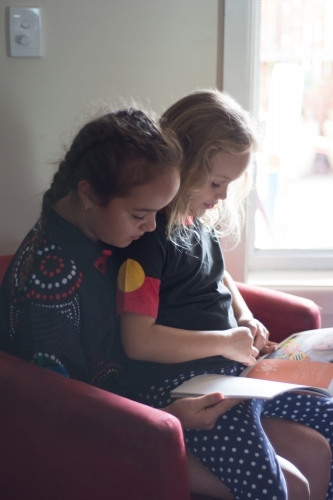 Sisters reading together - Australian Stock Image