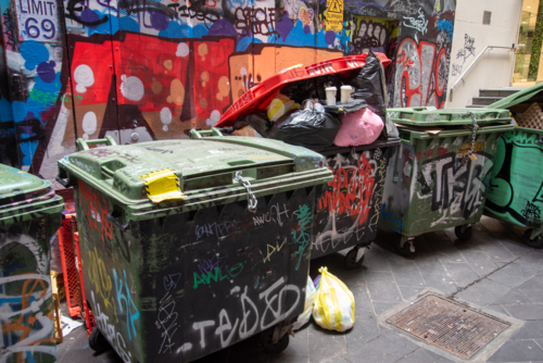 Skip bins in an alley with street art and graffiti - Australian Stock Image