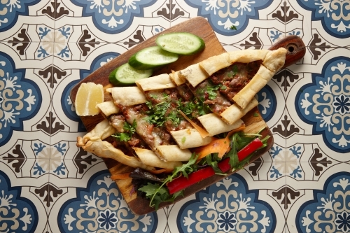 Sliced Lebanese bread with salad on board - Australian Stock Image