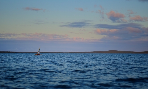 Small sailing boat in vast seascape between Bird Island and Turkey Beach, Queensland - Australian Stock Image