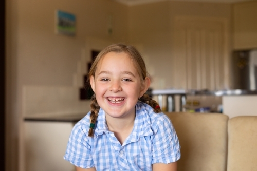 smiling child at home with toothy smile - Australian Stock Image