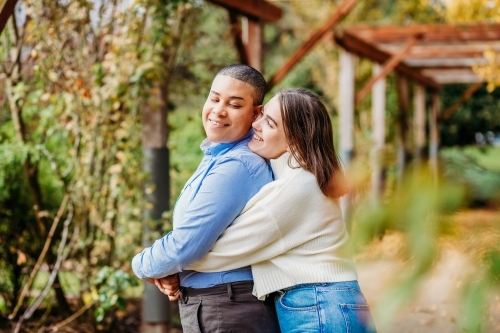 smiling lgbtqi couple, hugging - Australian Stock Image