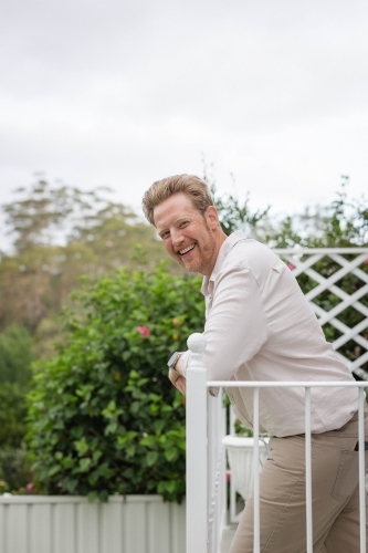 Smiling middle aged man on balcony - Australian Stock Image