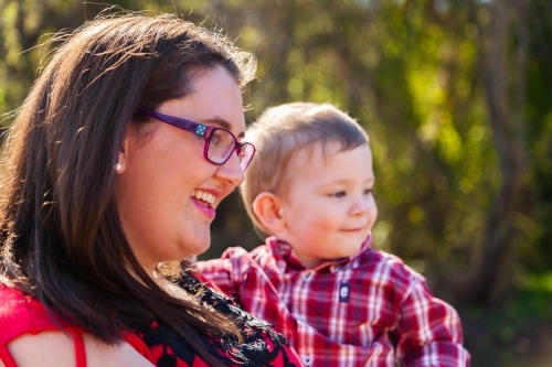 Smiling mother holding young son - Australian Stock Image