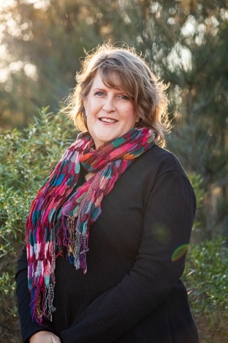 Smiling woman wearing bright scarf in winter - Australian Stock Image