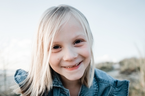 Smiling young girl with blonde hair and missing two front teeth - Australian Stock Image